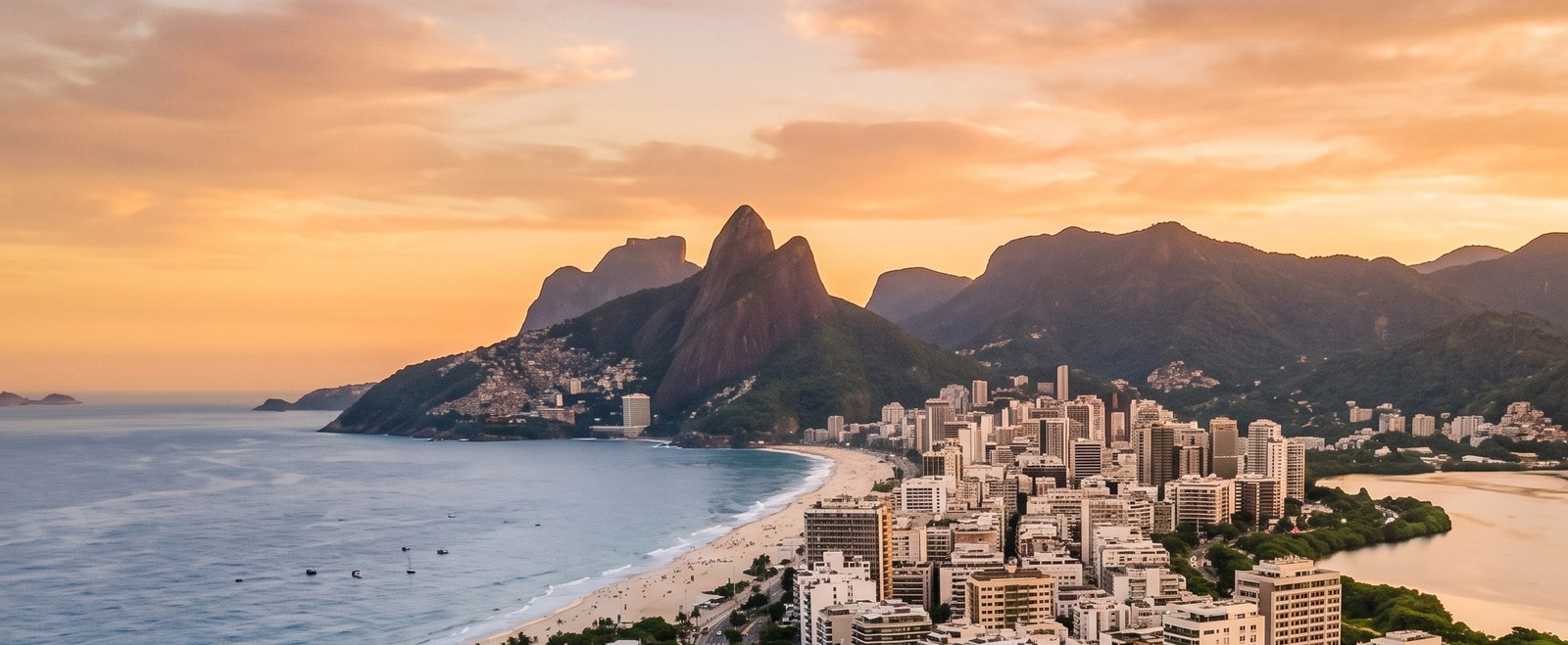 Vista aérea da Zona Sul do Rio de Janeiro ao pôr do sol, com a orla e prédios de alto padrão